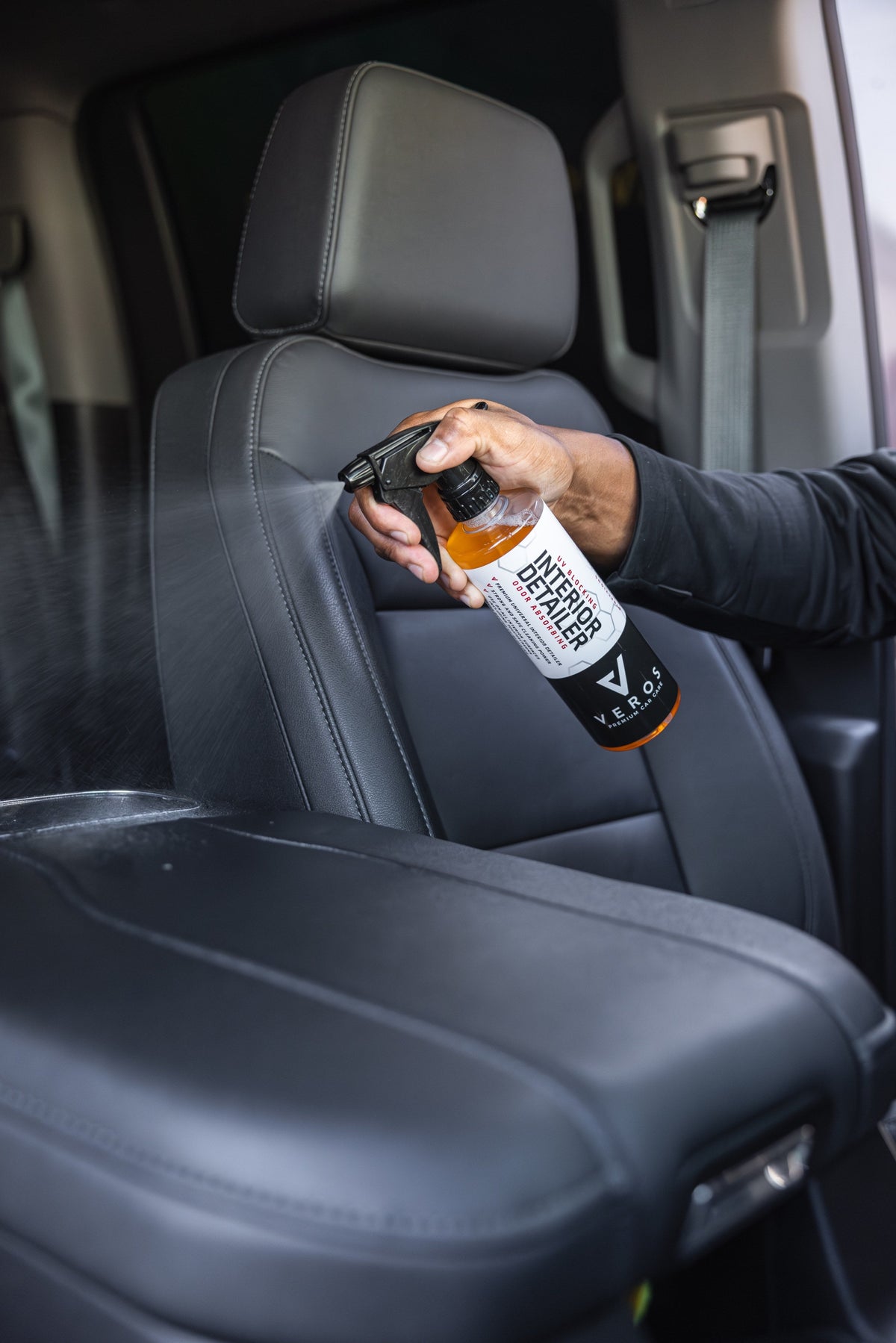 Spraying Universal Interior Detailer on a leather seat